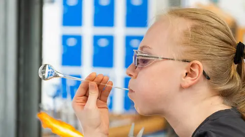 Eine Auszubildende beim Glasblasen im Bereich Glasapparatebau 