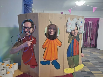 Faschingsparty im CJD Internat Ilmenau - 3 Personen schauen durch einen bunt bemalten Pappaufsteller
