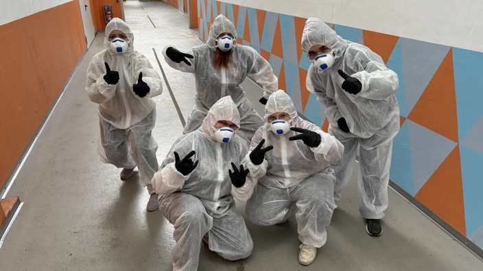  5 Jugendliche in Maler-Overalls und mit Maske