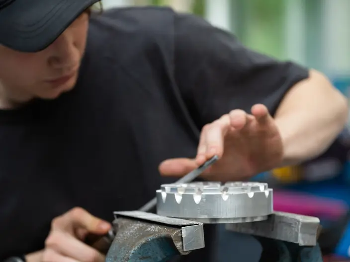 Ein Auszubildender bearbeitet ein Werkstück im Bereich Metalltechnik.