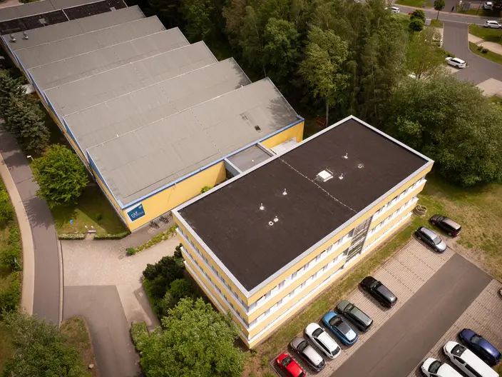 Luftbildaufnahme vom Beruflichen Bildungszentrum in Ilmenau. Das Verwaltungsgebäude ist im Vordergrund und die Ausbildungshallen im hinteren Bereich.